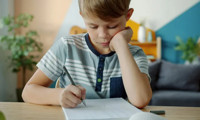 Child writing focused at desk — IEP goals should reflect real measurable learning