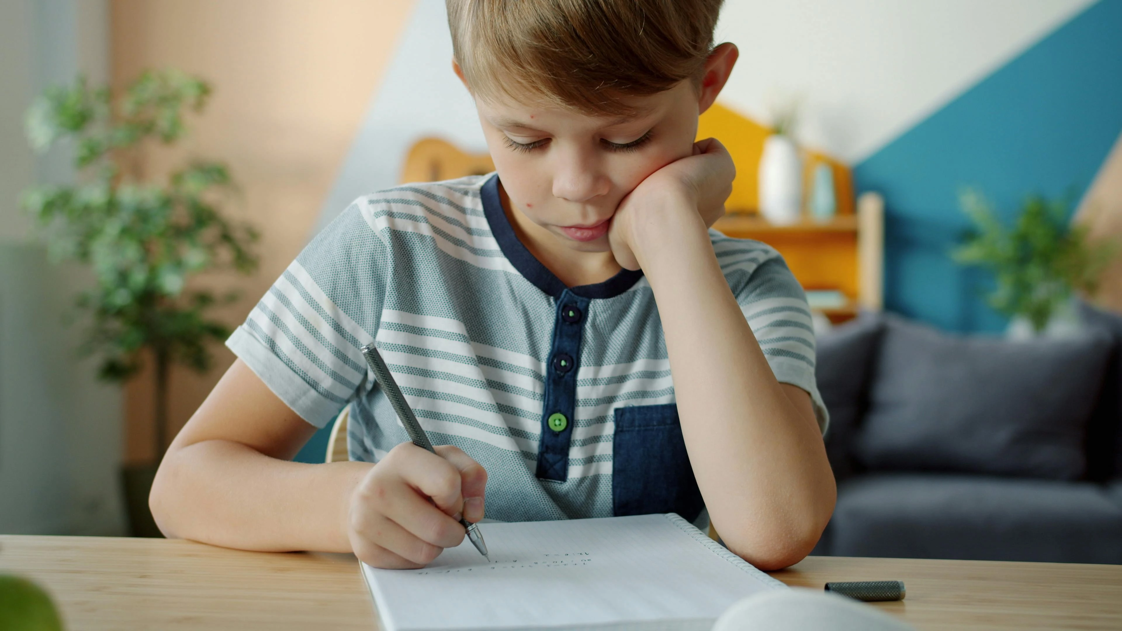 Child writing focused at desk — IEP annual goals should reflect real, measurable learning