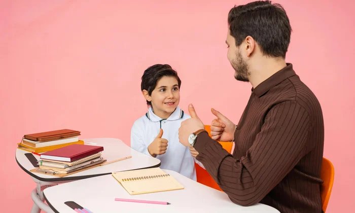 Niño y consejero dándose pulgares arriba en un escritorio