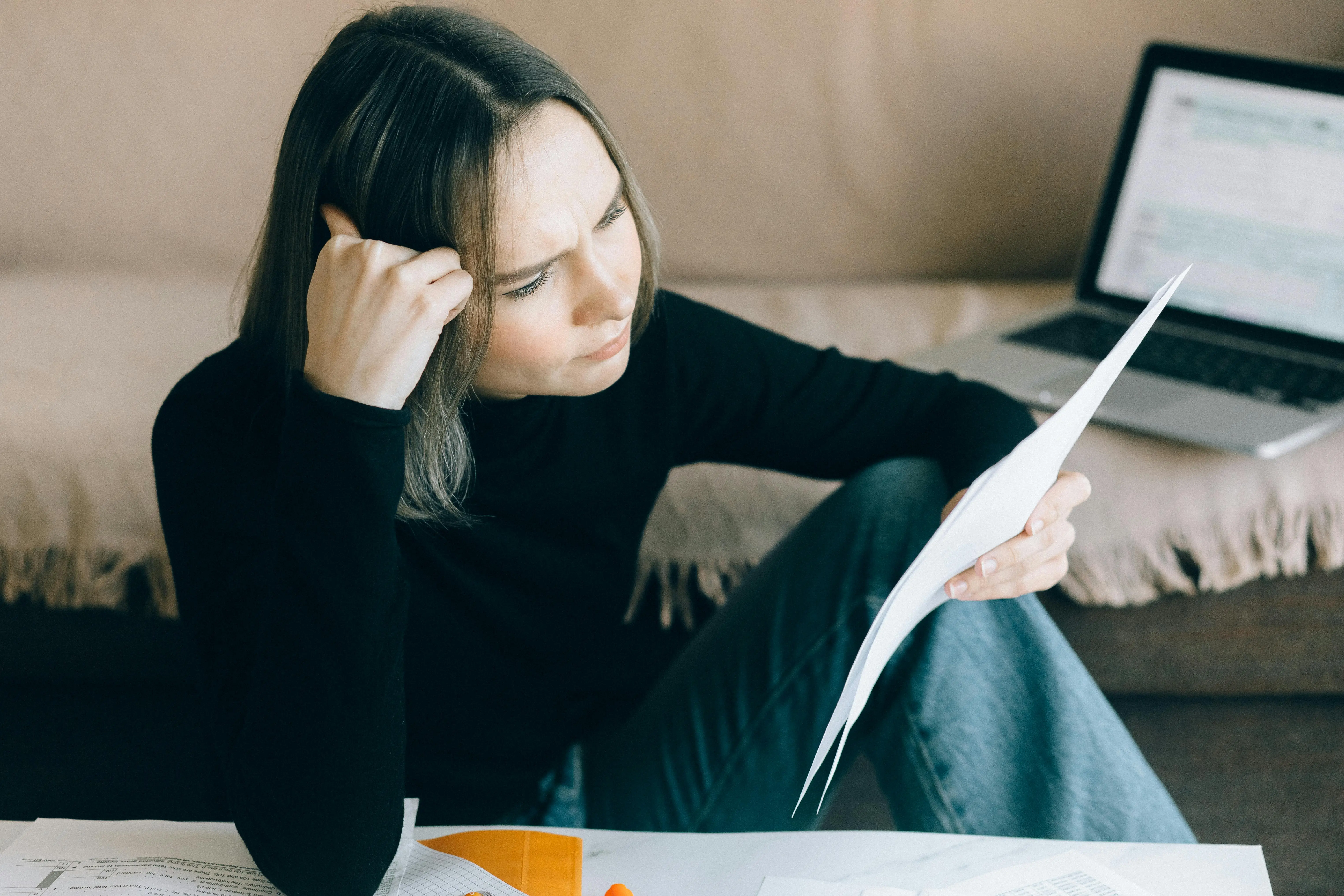 Madre agobiada leyendo documentos del IEP en casa